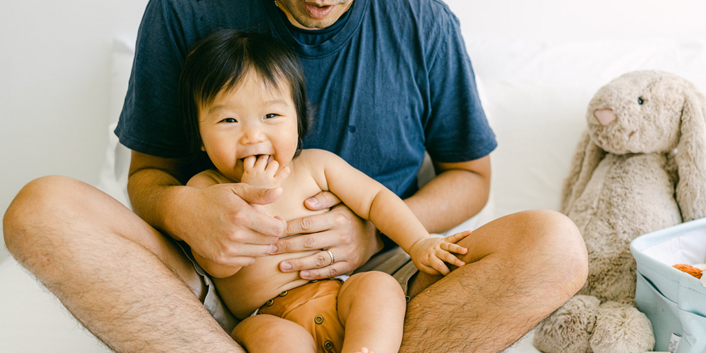 Dad holding his baby in Just Peachy cloth diaper