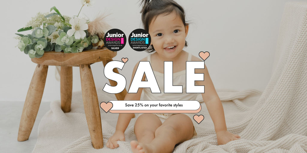 Baby sitting on a blanket with a wooden stool and flowers, promotional banner for Just Peachy Black Friday sale.